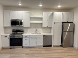 New construction kitchen featuring custom white cabinetry and stainless steel appliances