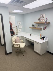 Custom office workspace with built-in desk, floating wood shelves, and modern cabinetry